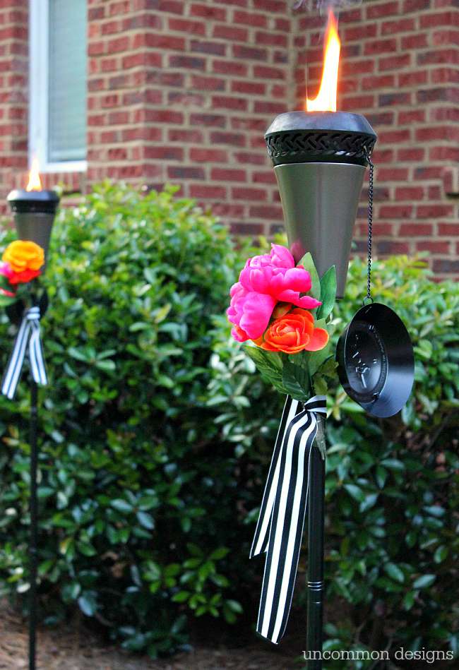 Dress up your tiki torches.  These floral tiki torches would be gorgeous for a wedding or garden party.  Add a few faux flowers and some striped ribbon and you are done! by Uncommon Designs 