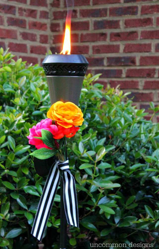 Dress up your tiki torches.  These floral tiki torches would be gorgeous for a wedding or garden party.  Add a few faux flowers and some striped ribbon and you are done! by Uncommon Designs 