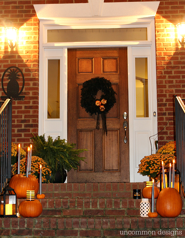 Make pumpkins into candle holders for your battery operated taper and pillar candles. So easy, but such a creative Halloween porch idea! | Uncommon Designs 