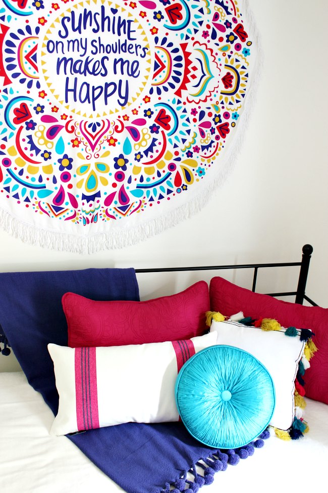 Boho Girls Room  with Benjamin Moore's Simply White, a colorful wall hanging, daybed with loads of gorgeous pillows | Uncommon Designs