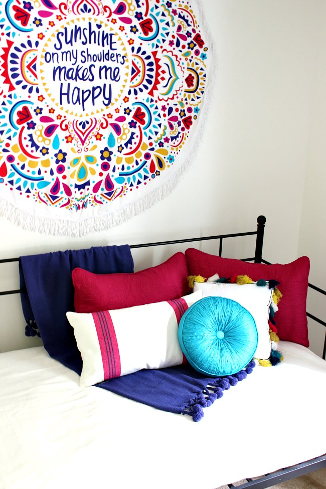 Boho Girls Room  with Benjamin Moore's Simply White, a colorful wall hanging, daybed with loads of gorgeous pillows | Uncommon Designs