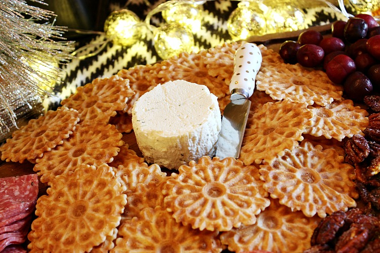 How to wow your guests with an upscale holiday appetizer board. Boursin gourmet cheese, crackers, nuts, salami and a sweet fruit make it a simple appetizer. 