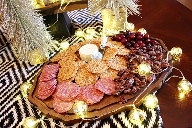 How to wow your guests with an upscale holiday appetizer board. Boursin gourmet cheese, crackers, nuts, salami and a sweet fruit make it a simple appetizer. 