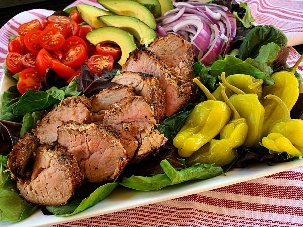 Fire up the grill for this delicious and cracked black pepper recipe for garlic and herb grilled pork tenderloin salad with loads of toppings. A great grilling recipe for summer!