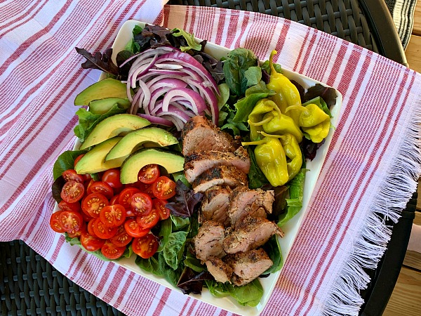 Fire up the grill for this delicious and light recipe for garlic and cracked black pepper grilled pork tenderloin salad with loads of toppings. A great grilling recipe for summer!